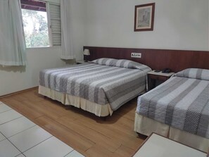 A hotel room with two beds, a nightstand, a lamp, and a framed picture on the wall. - Hotel Fazenda Fonte Colina Verde (São Pedro)