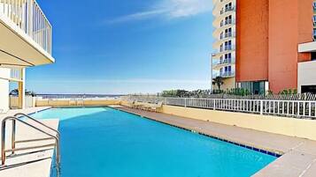 A swimming pool with a view of the ocean, surrounded by buildings.
