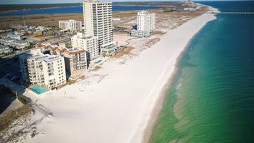 A coastal area with beachfront hotels, a sandy beach, and a clear blue ocean.