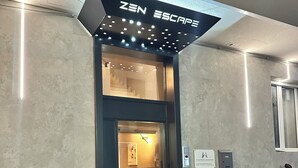 A modern building entrance with a sign reading 'ZEN ESCAPE.' - zen escape (San Gregorio di Catania)