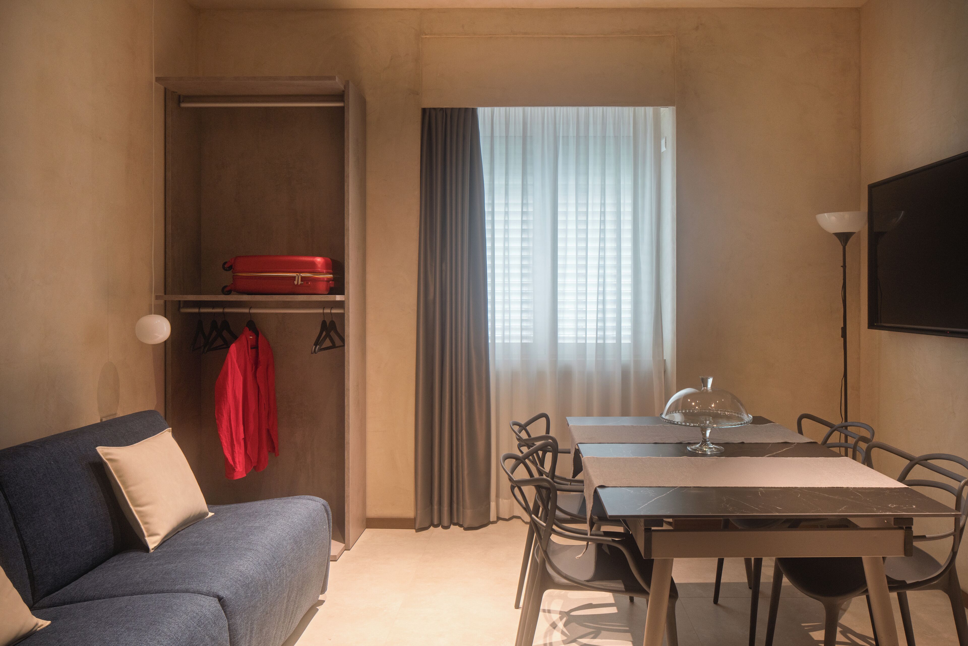 Una habitación compacta con sofá, una mesa de comedor y televisión.