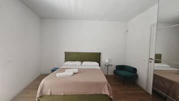 Un dormitorio con cama, una silla, una mesita de noche y un armario.