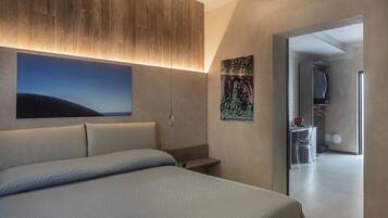 Ein modernes Schlafzimmer mit einem großen Bett, einem Kopfteil mit integrierter Beleuchtung, einem an der Wand befestigten Fernseher und Blick ins angrenzende Badezimmer.