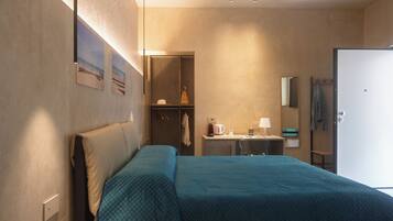 Une chambre d’hôtel avec un lit, un bureau, un miroir et une armoire.