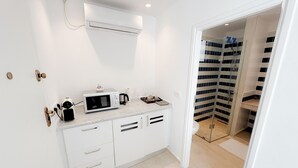 A modern kitchen with a microwave, coffee maker, and a small cabinet. - The Amazing Studio in Site Arch Ologique de Carthage (La Marsa)