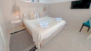 A bedroom with a bed, a TV, a chair, and a small table. - The Amazing Studio in Site Arch Ologique de Carthage (La Marsa)
