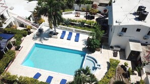 A rooftop pool with blue lounge chairs and a small circular hot tub. - Airisha Villa Paradise (Los Patos)
