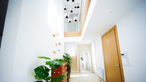 A modern hallway with a wooden door, a glass ceiling, and a staircase leading to an upper level. - Villa Hermes Seaside and Luxurious (La Marsa)