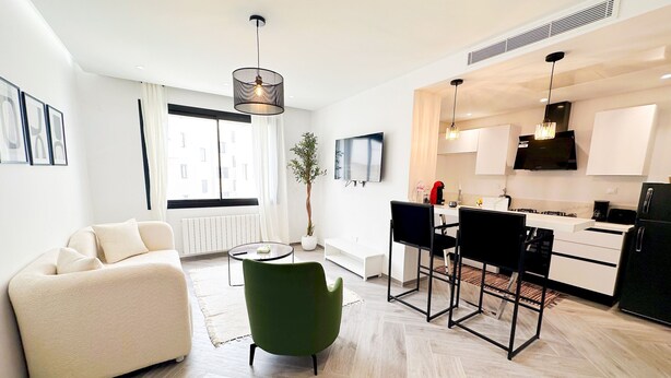 Ein modernes Apartment mit Wohnzimmer, Essbereich und Küche.