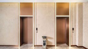 A modern elevator with a metallic finish and a small trash bin in the center. - Lavande Hotel (Wuhan High-speed Railway Station) (Wuhan)