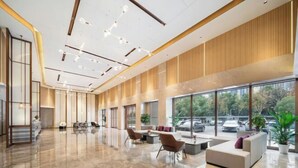 A spacious lobby with a modern design, featuring a large seating area, a reception desk, and large windows offering a view of the outside. - Lavande Hotel (Wuhan High-speed Railway Station) (Wuhan)