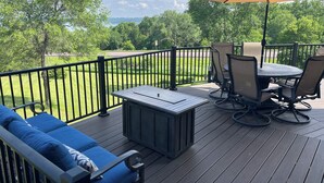 Una terraza con mobiliario exterior, incluyendo una mesa y sillas, y una sombrilla grande.