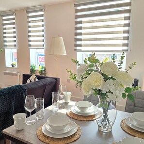 Comedor con una mesa dispuesta para cuatro personas, con platos, tazones y vasos.