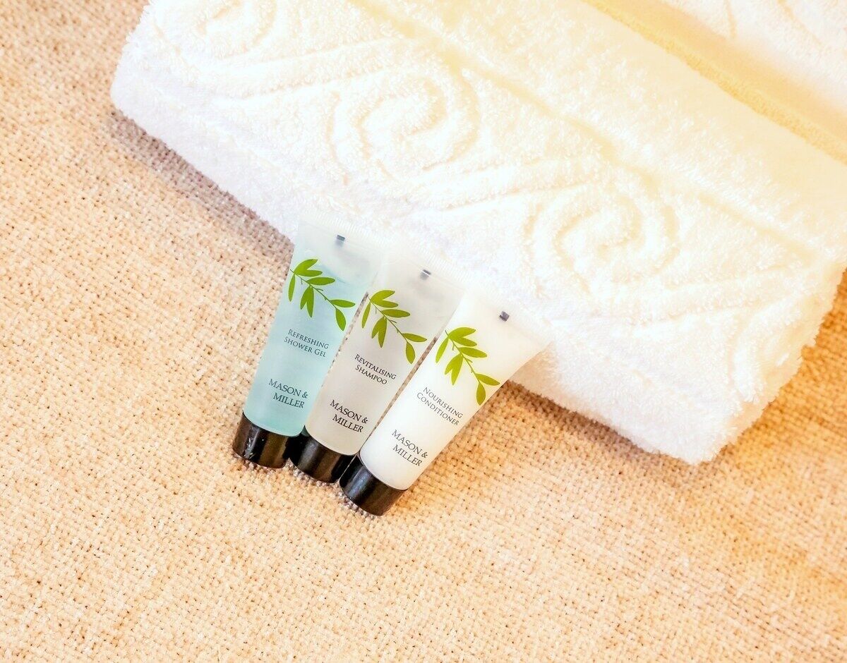 Three Mason & Miller hair care products on a textured beige surface.