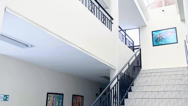 Un escalier avec une rampe métallique menant à l’étage supérieur.