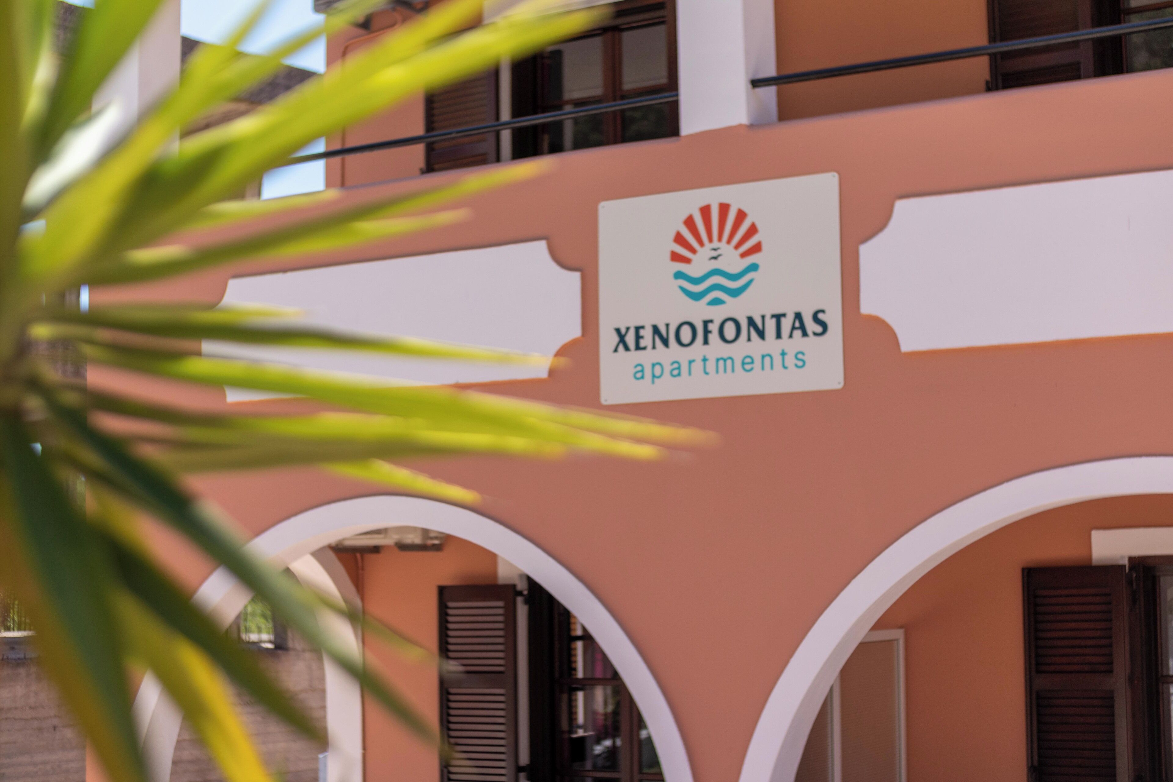 A building with a sign that reads "Xenofontas apartments."