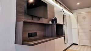 A modern room with a built-in TV, a coffee machine, and a small shelf. - Shanghai Jinrui Hotei （Linyi Road ） (Shanghai)