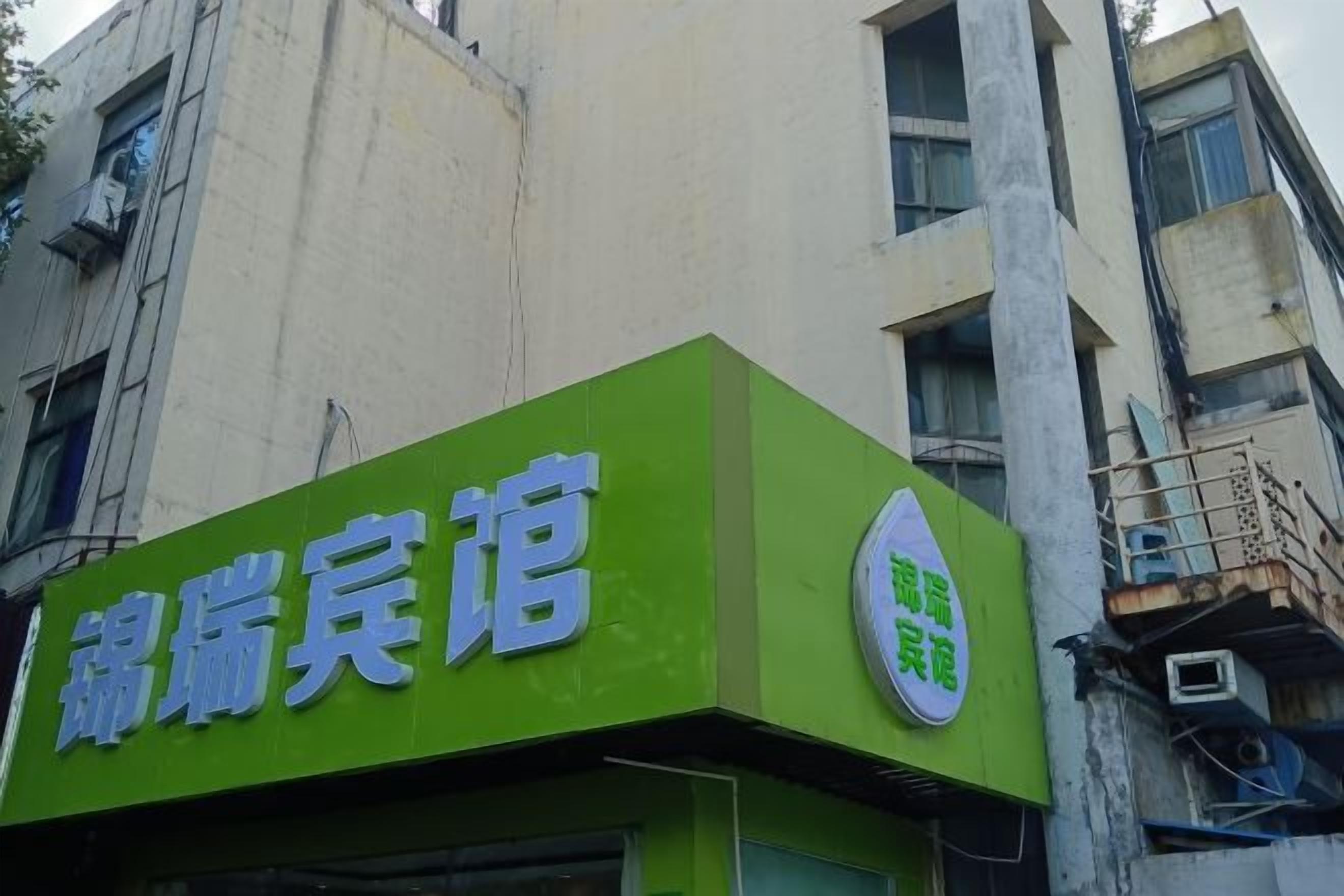 Un edificio con un letrero verde que dice 'Hotel'.