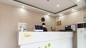 A reception desk with a computer, a clock, and a refrigerator. - Shanghai Jinrui Hotei （Linyi Road ） (Shanghai)