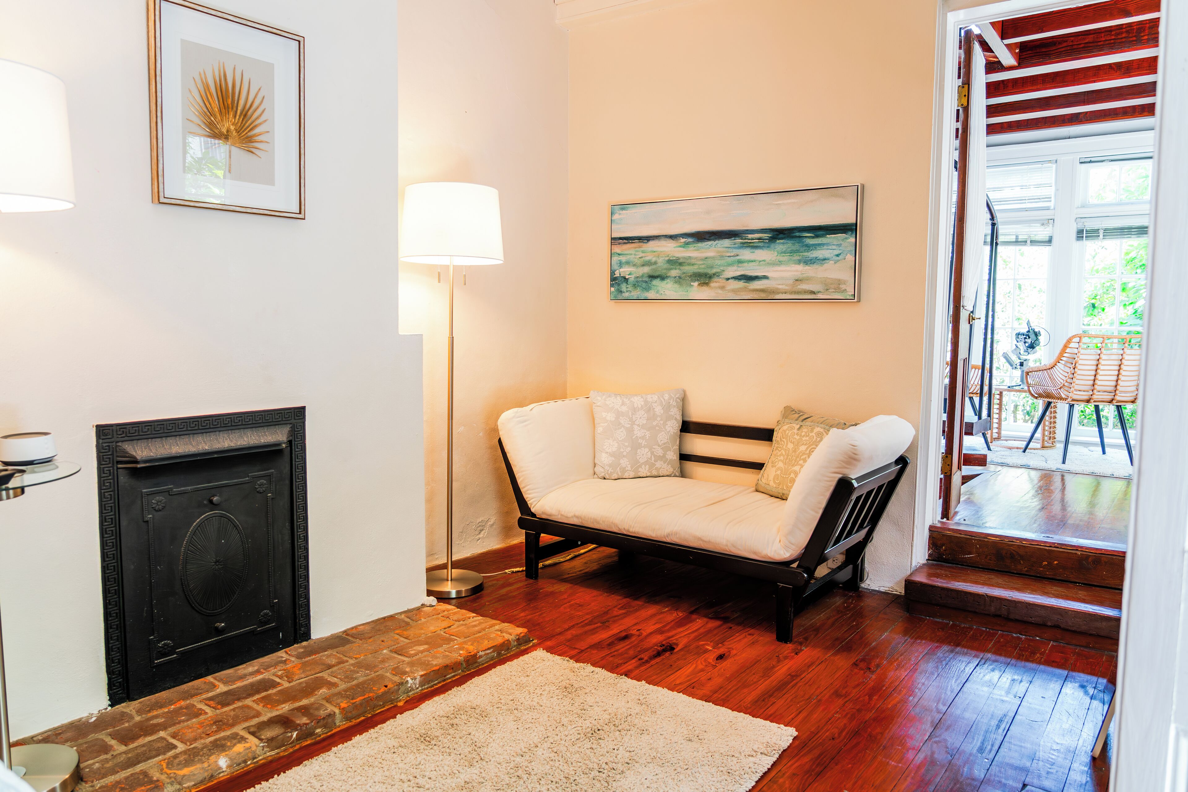 A cozy living room with a fireplace, a sofa, and a painting on the wall.