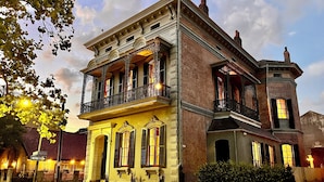 A historic building with a balcony, large windows, and a brick facade. - The Lanaux Mansion (New Orleans)