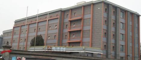 A multi-story building with a flat facade, several windows, and a sign indicating it is a hotel.