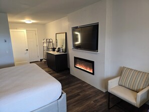 Relax in a spacious room with a large bed, flat-screen TV, and cozy fireplace.