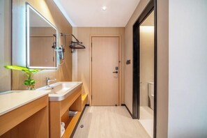 A modern bathroom with a wooden vanity, a large mirror, and a plant. - 99 Xinyi Hotel (Shanghai Jiuxin Highway Shop) (Shanghai)