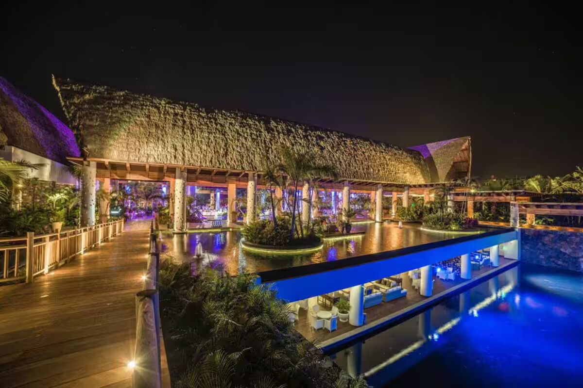 Ein Resort mit großem Pool, einer überdachten Sitzgelegenheit und einer Holzterrasse.