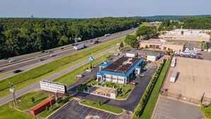 A commercial building with a parking lot and a highway in the background.