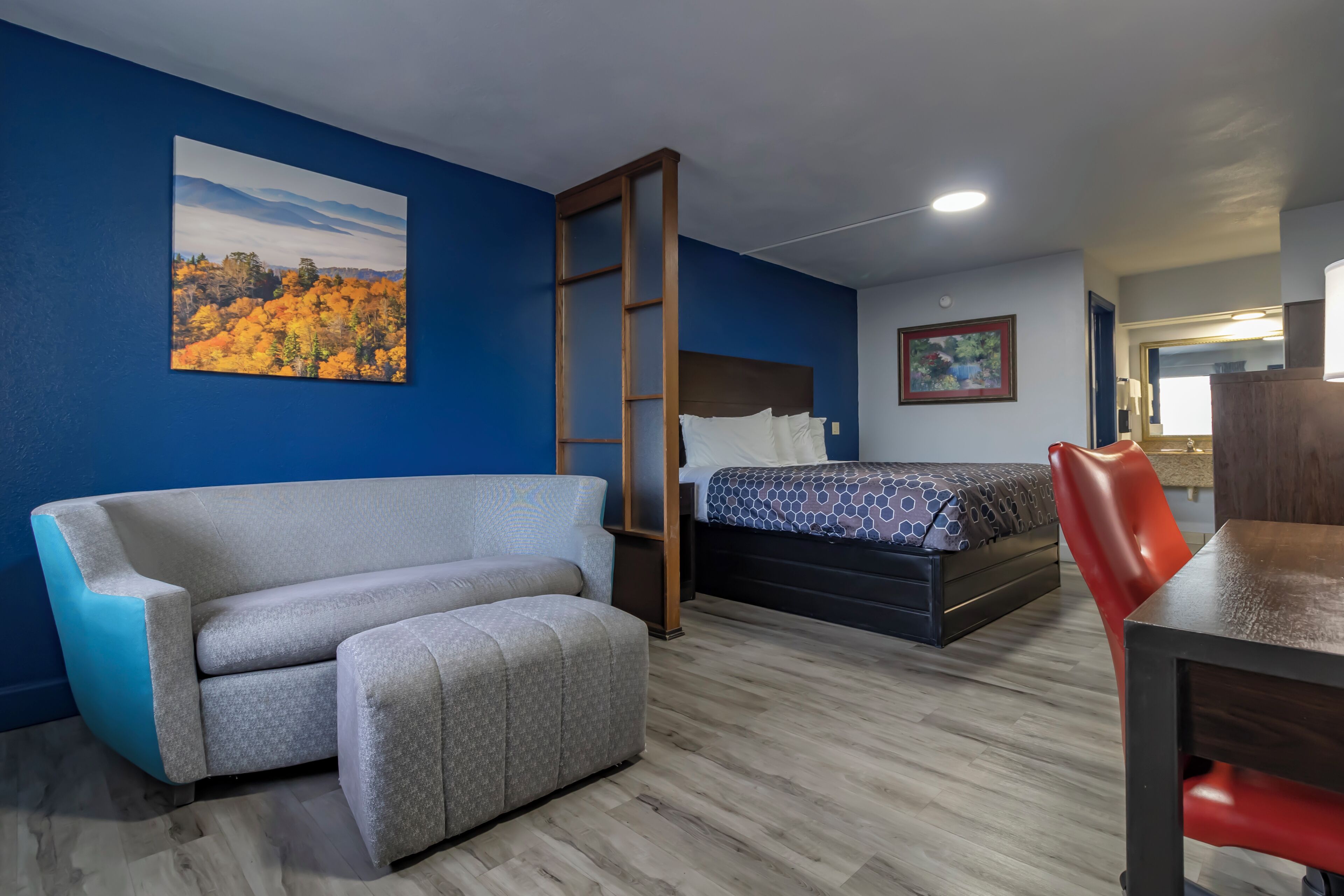 Una habitación de hotel con sofá, cama, escritorio y silla.