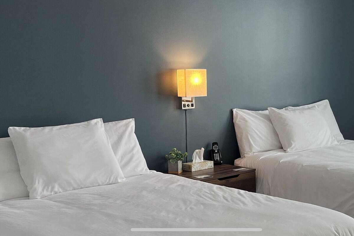 Ein Hotelzimmer mit zwei Betten, einem Nachttisch mit Lampe und einem Telefon.