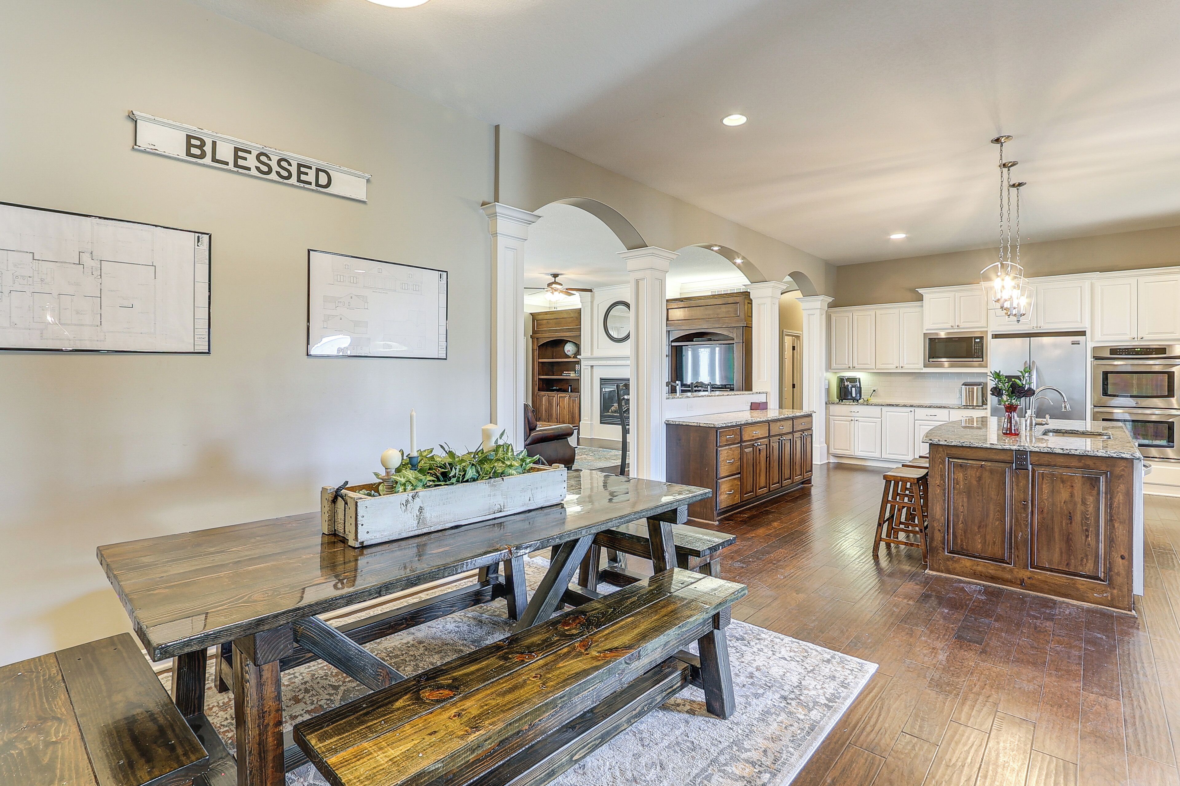 A spacious kitchen with white cabinets, a wooden island, and a dining area with a bench.