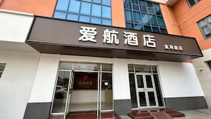 L’entrée d’un hôtel, avec une enseigne indiquant « 爱航酒店 » en chinois et « Love Hotel » en anglais.