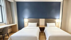 Une chambre d’hôtel avec deux lits, un bureau et une vue sur la ville.