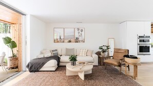 A modern living room with a sectional sofa, a coffee table, and a dining area with a chair and table.