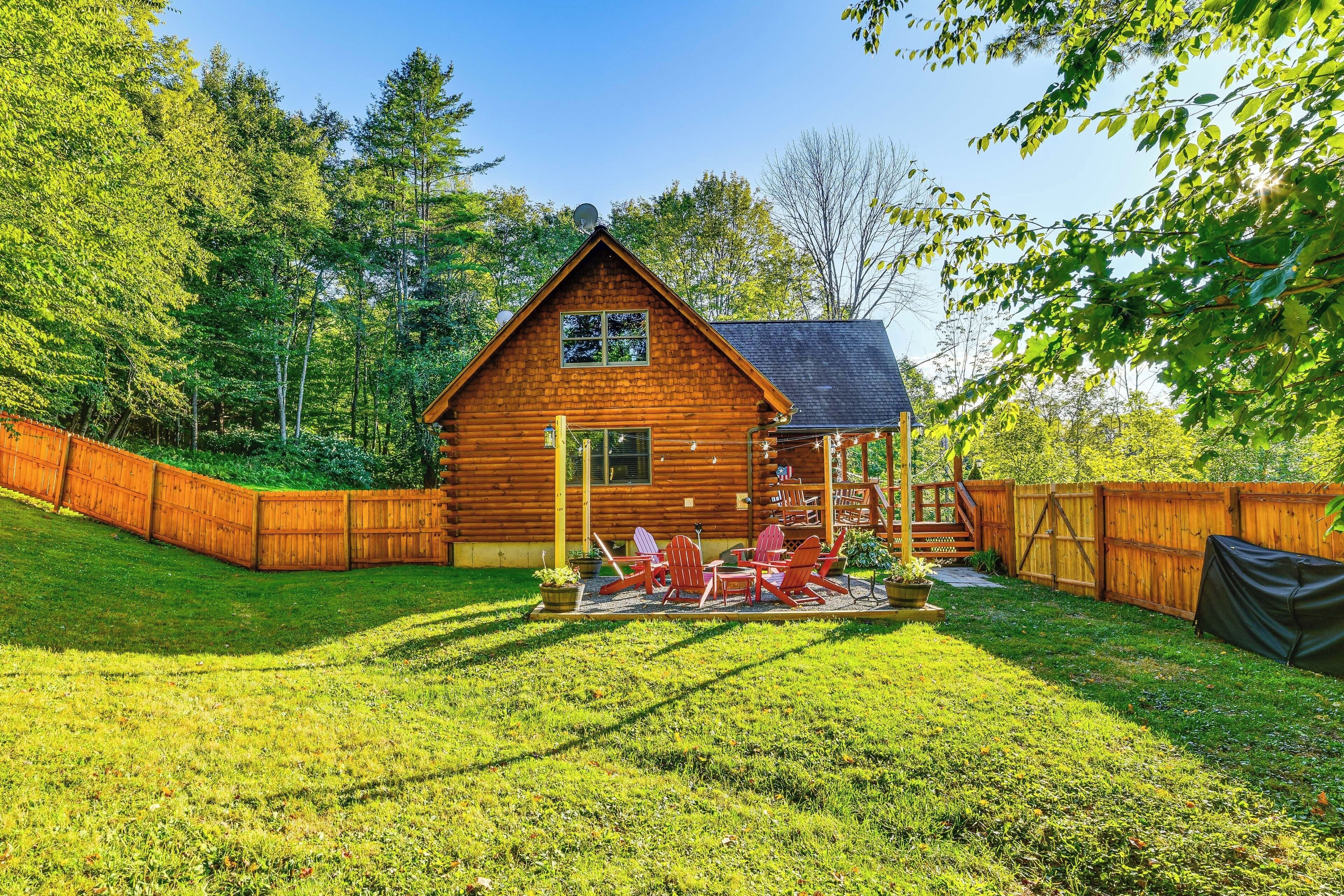 A wooden cabin with a deck and outdoor seating area.