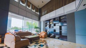 A modern lobby with a checkered floor, a sofa, a coffee table, and a bookshelf. - Pizhou Dihao Jingzhi Hotel (Pizhou)