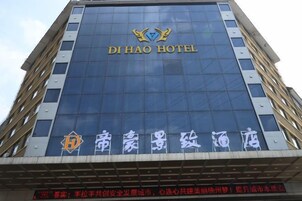 Um edifício de hotel com uma placa grande que diz 'DI HAO HOTEL' e um logotipo acima.