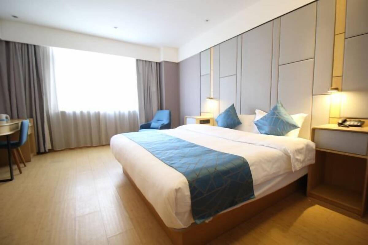 Ein Hotelzimmer mit einem großen Bett, einem Schreibtisch und einem Stuhl.
