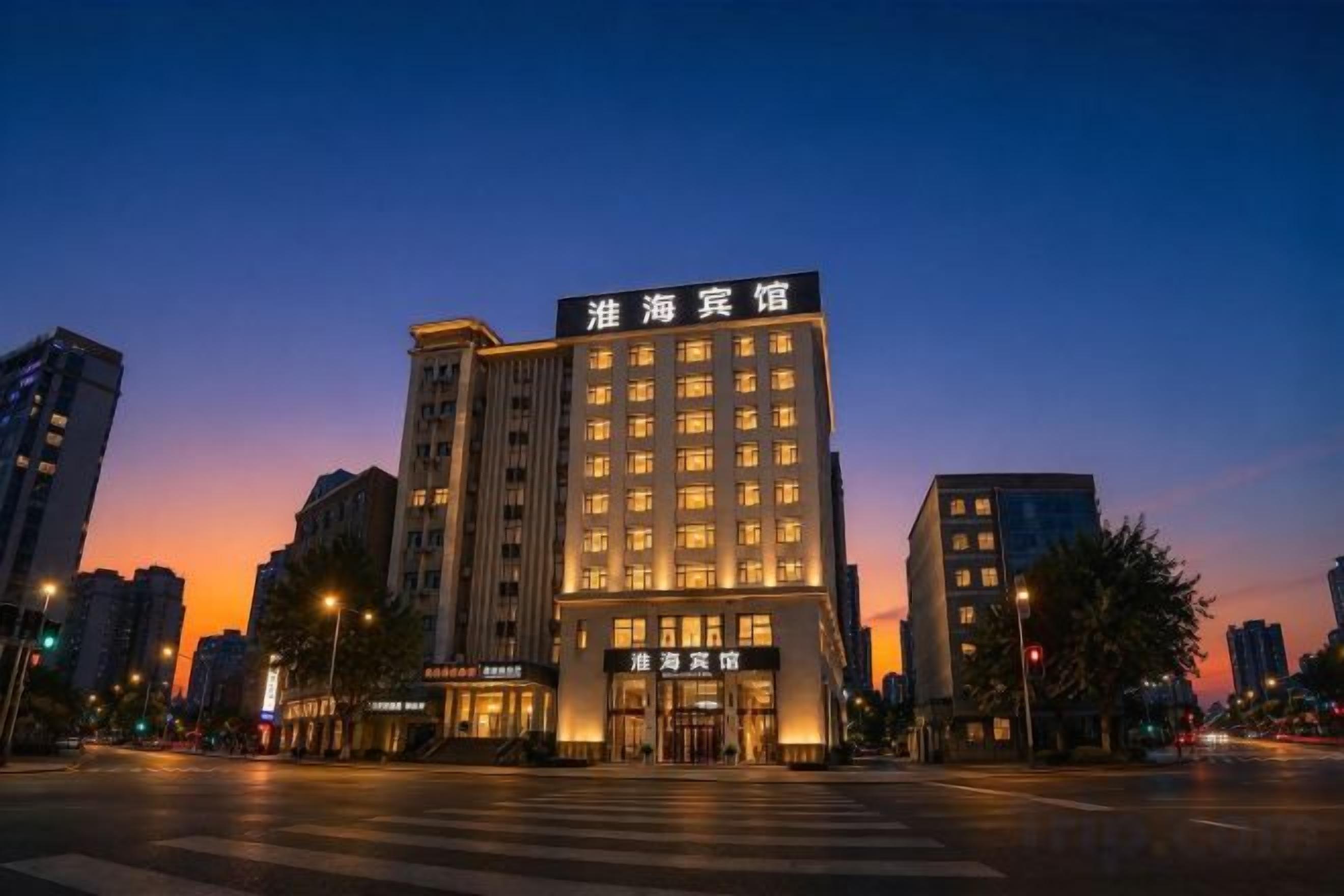 A multi-story hotel with a prominent entrance and signage, located at a city intersection.