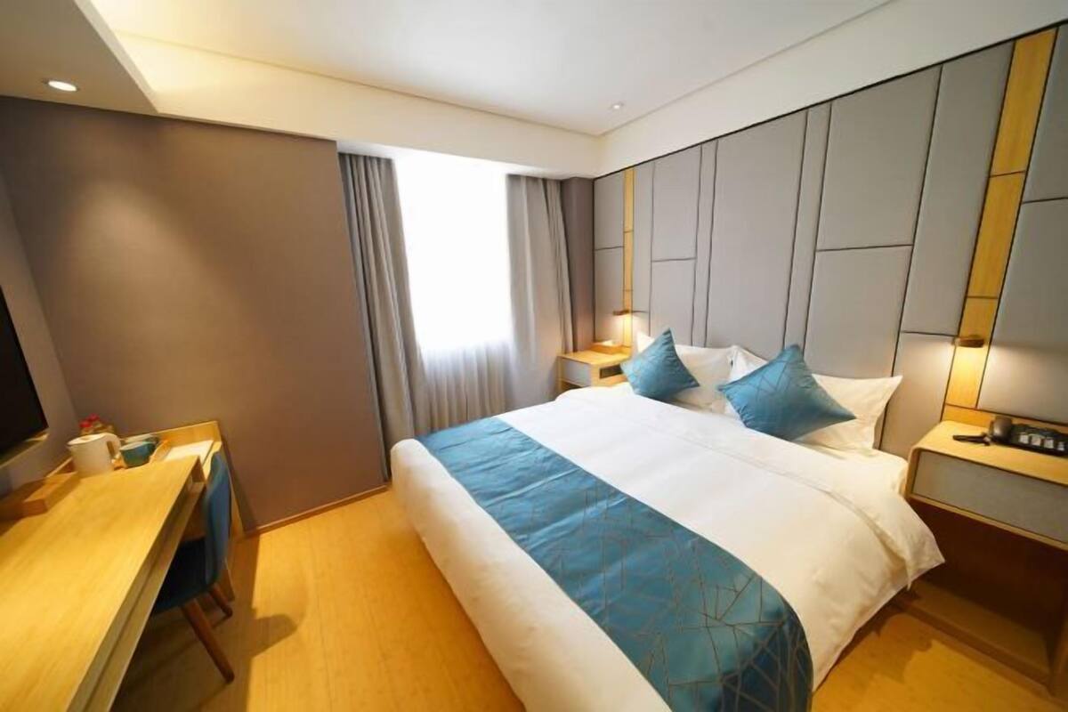 Ein Hotelzimmer mit einem großen Bett, einem Schreibtisch und einem Fernseher.