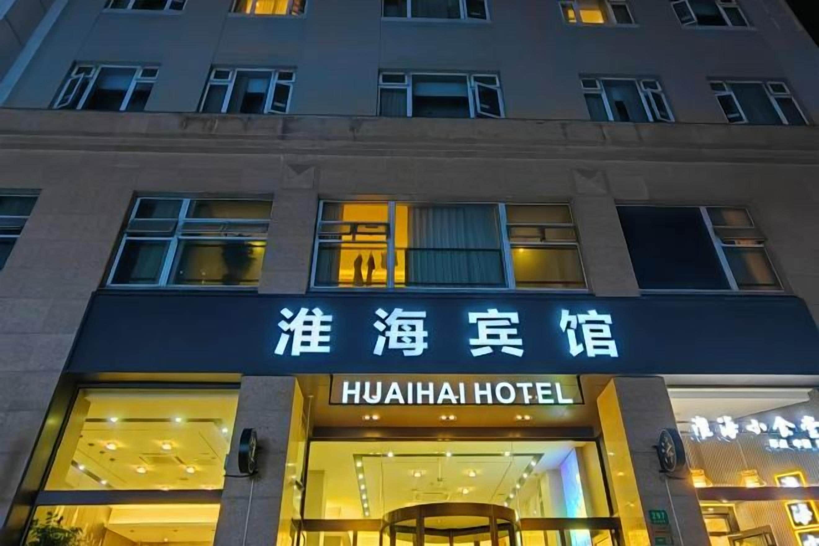 A hotel entrance with a sign in both Chinese and English.