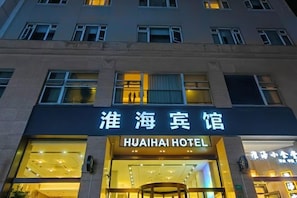Een hotelingang met een bord in zowel Chinees als Engels.