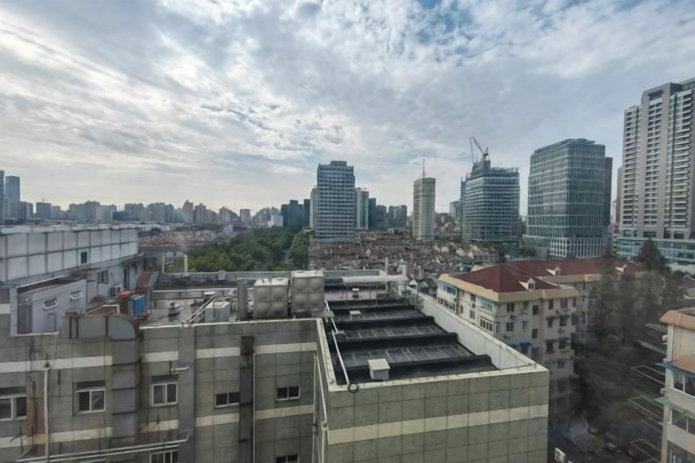 Stadsbeeld met hoge gebouwen, een heldere lucht en een dak met een vlak oppervlak.