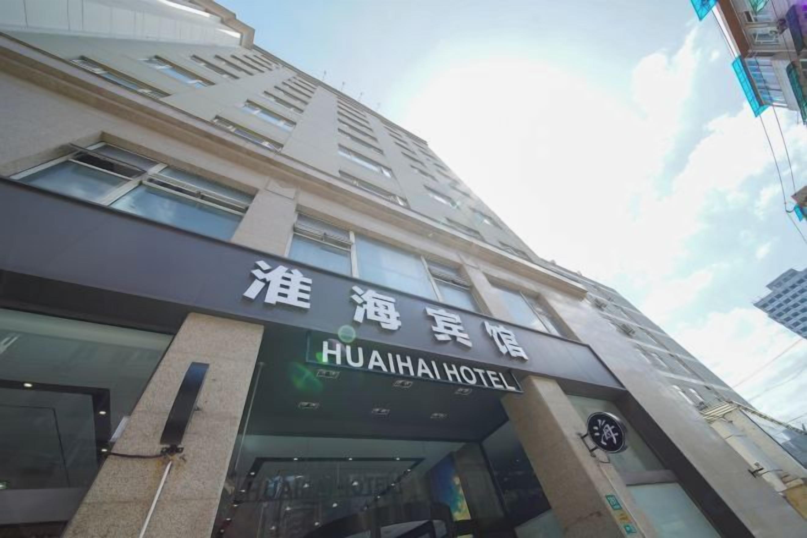 A hotel building with a sign that reads 'HUAHAI HOTEL'.