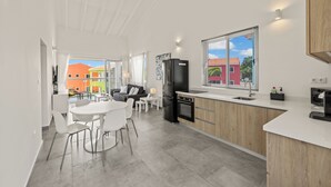 Una cocina moderna con horno empotrado, un refrigerador negro y una ventana con persianas.