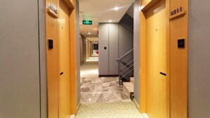 A hotel hallway with wooden doors numbered 8211 and 8212, leading to a staircase. - Accompanying Hotel·Yipin (Shanghai Lujiazui Financial and Trade Zone) (Shanghai)