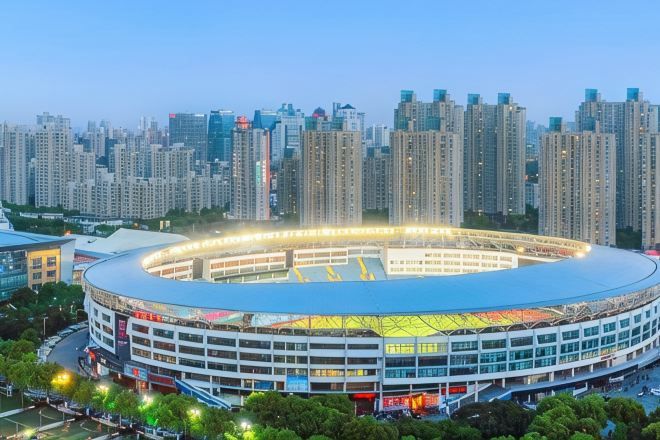 Een groot stadion met een rond ontwerp, omringd door hoge gebouwen.
