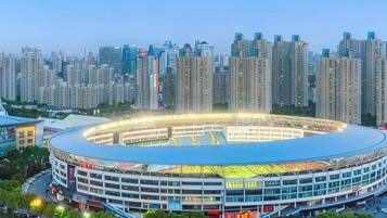 Een groot stadion met een rond ontwerp, omringd door hoge gebouwen.